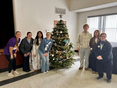 Servant Leadership Academy students beside a decorated Christmas tree during the Christmas Dinner Drive